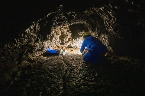 Scientists exploring a cave system with flashlights