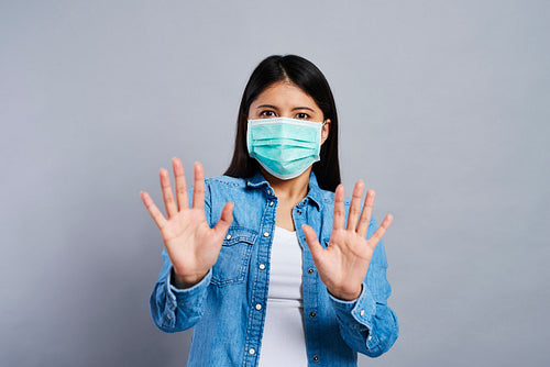 Frightened Asian woman in surgical mask