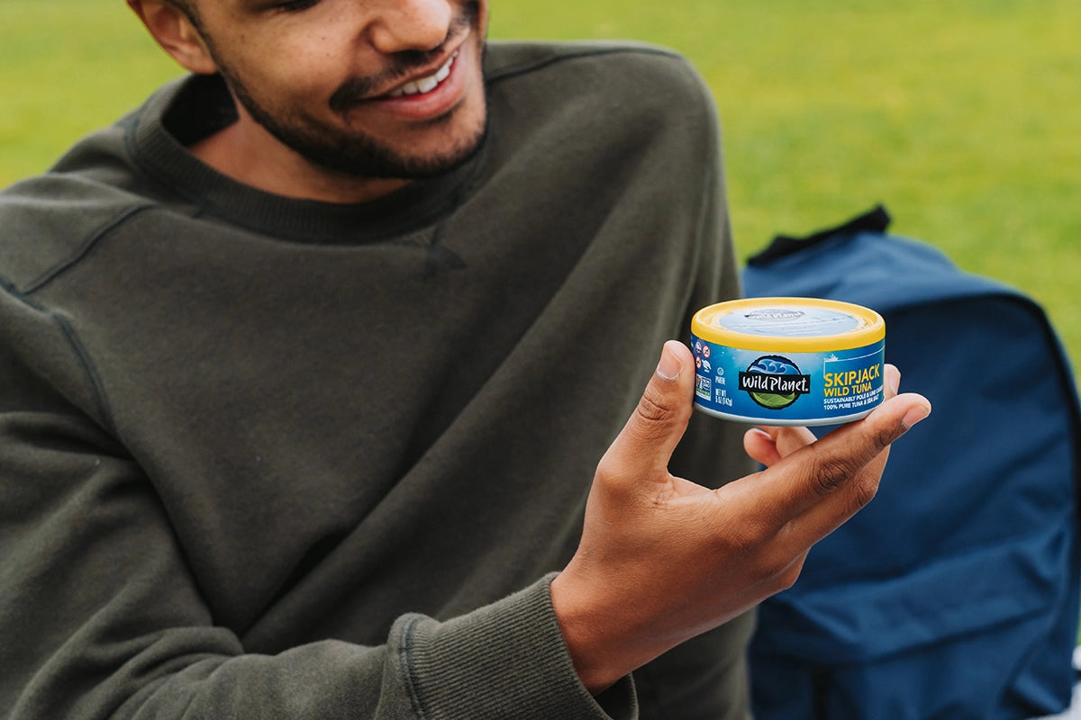 Man holding Wild Planet Skipjack Wild Tuna can