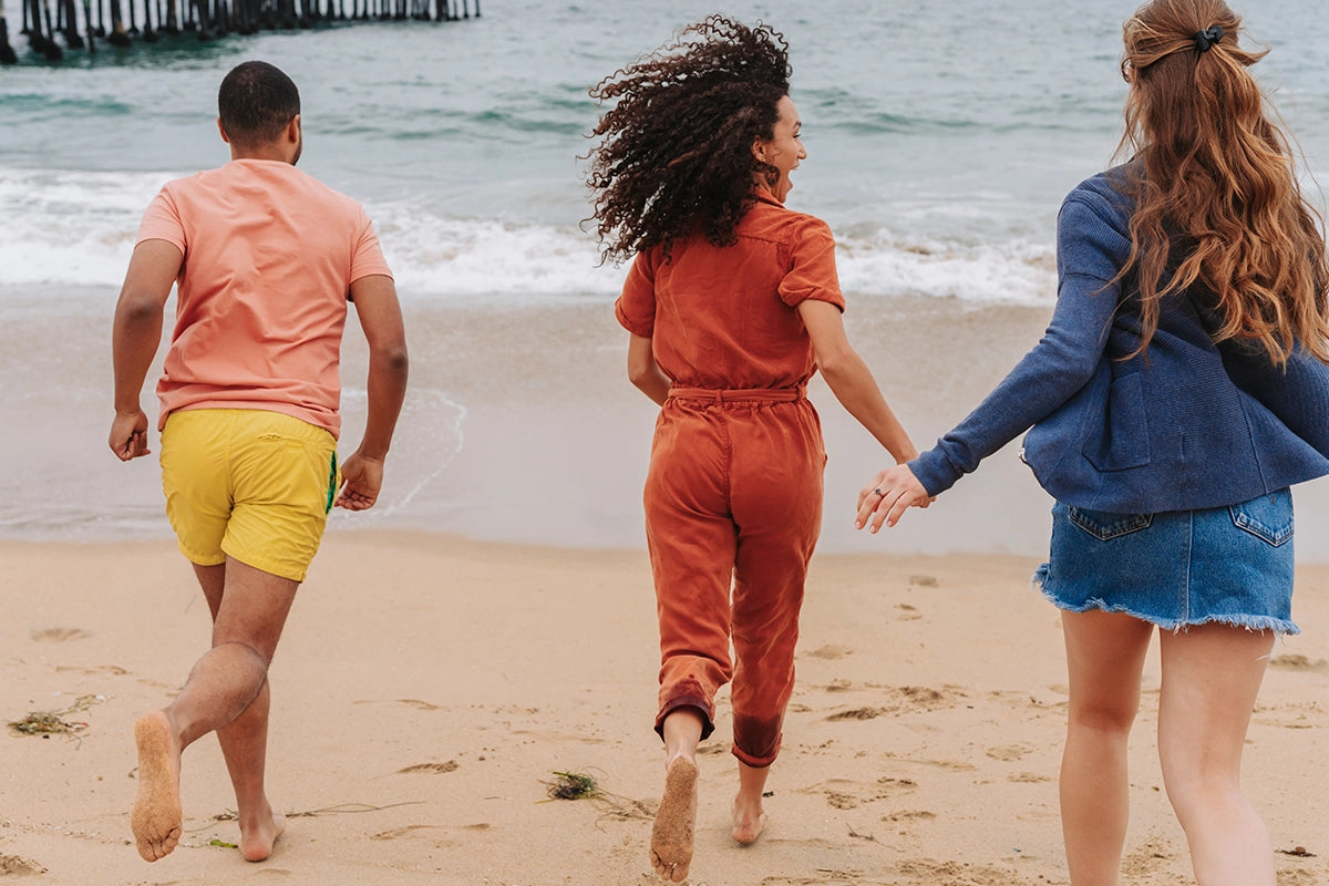 Friends running on beach towards ocean