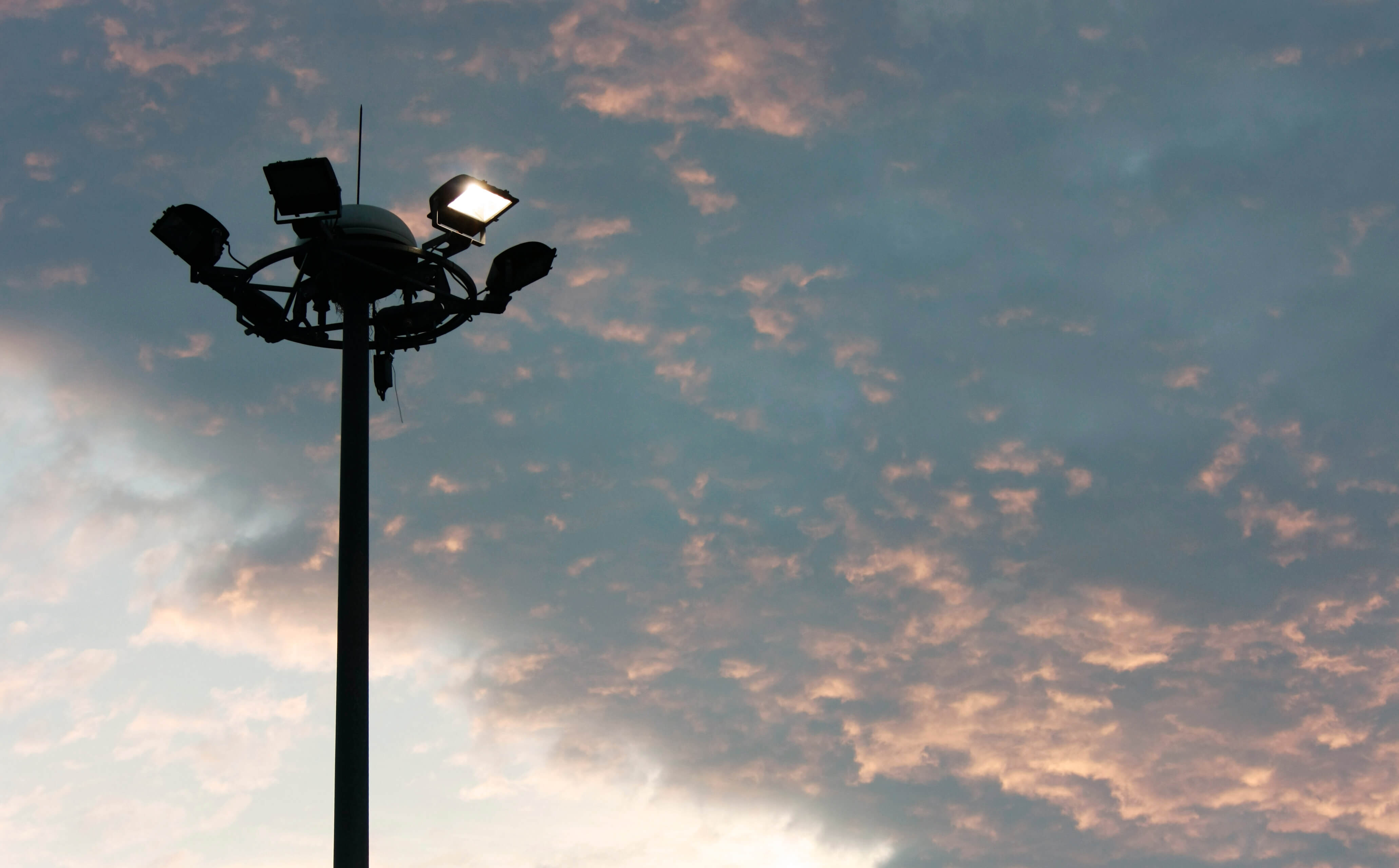 A shot from below of an LED flood light against a moody evening sky.