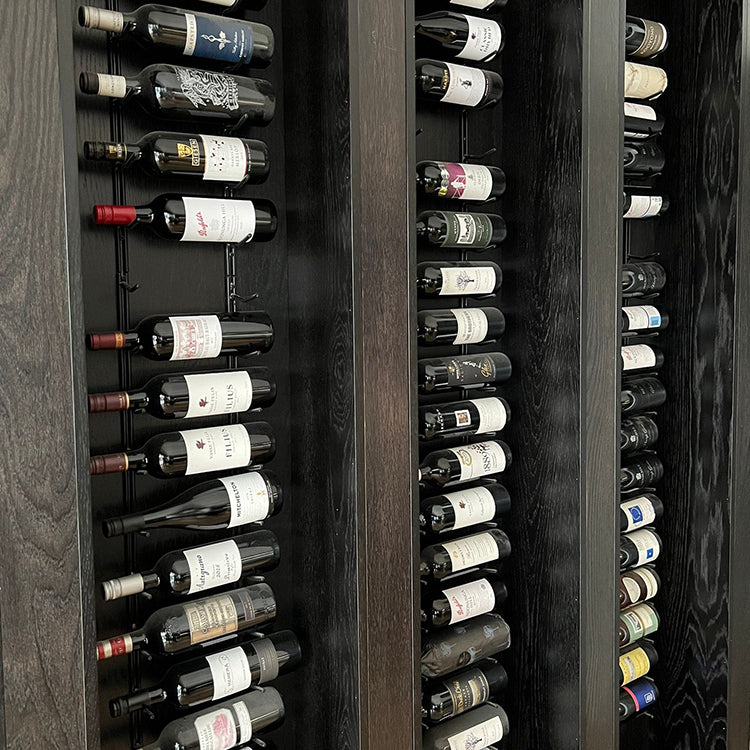 A wall with 3 columns of hanging wine racks