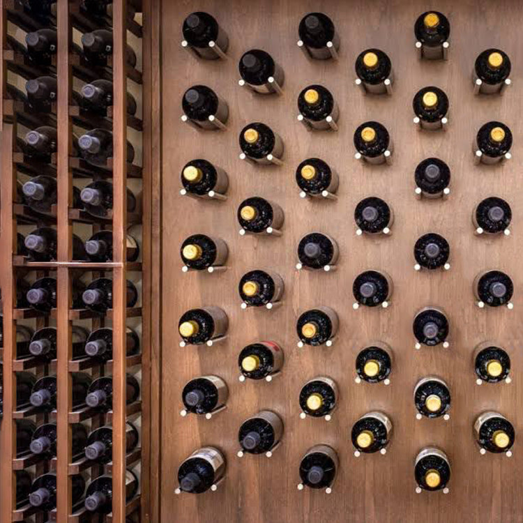 Wine bottles resting on wine pegs and inside wine racks