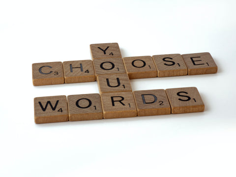 scrabble tiles spelling out "chose your words"