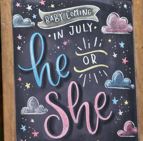 blackboard sign that says "baby coming in july he or she"