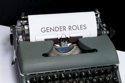 a typewriter with a paper in it with the words "gender roles" in all caps