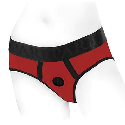 a red and black pair of briefs with a hole in the center of the crotch to act as a harness for a strap on dildo, worn on a white mannequin crotch