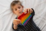 Young kid playing with rainbow fidget toy