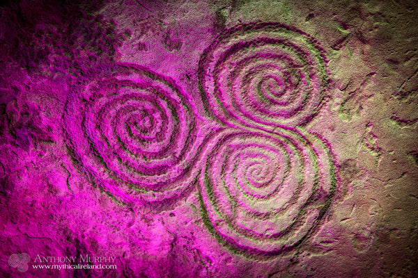 The triple spiral of Newgrange, lit up in pink