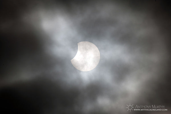 Partial eclipse of the sun behind cloud