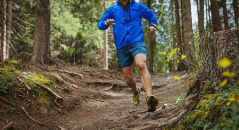 Man running on outdoor terrain in woods