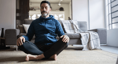 Man indoors meditating on the floor