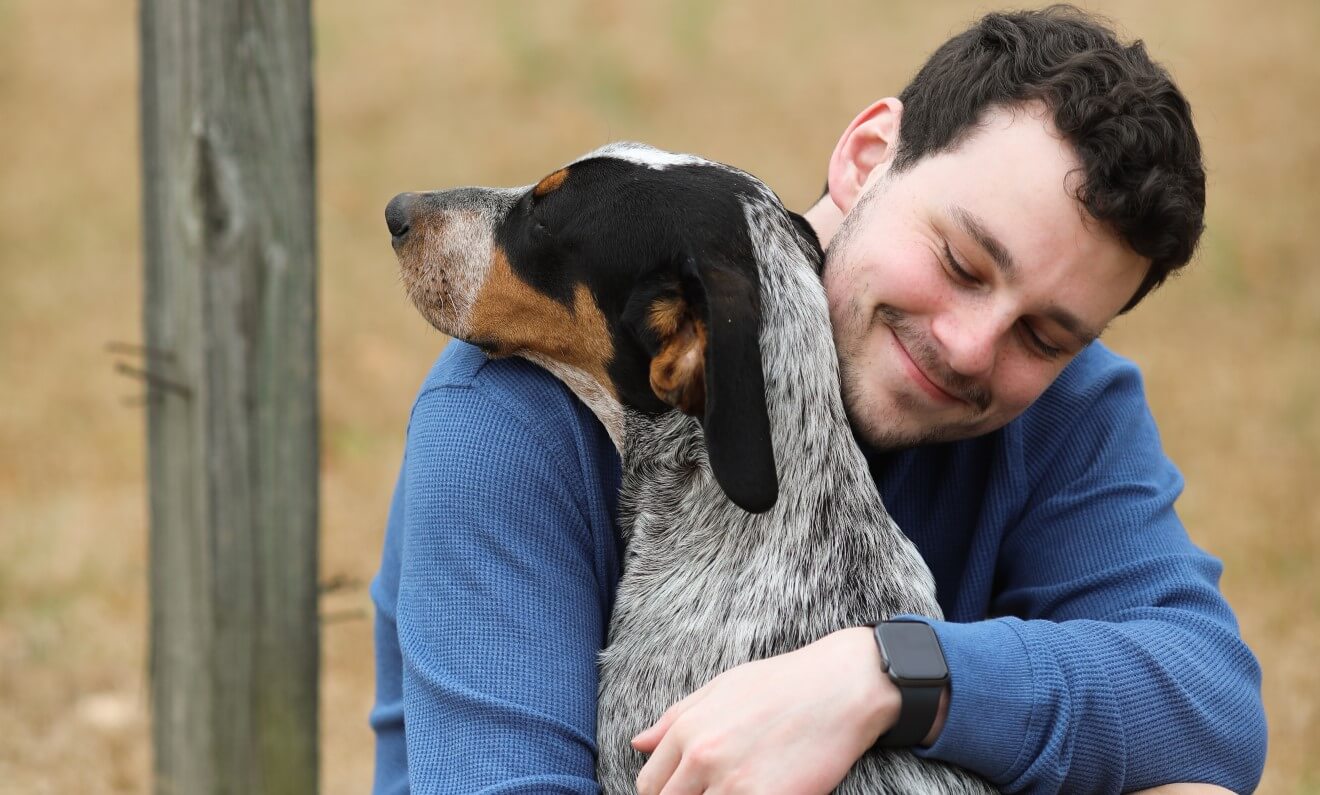 a man hugging a dog