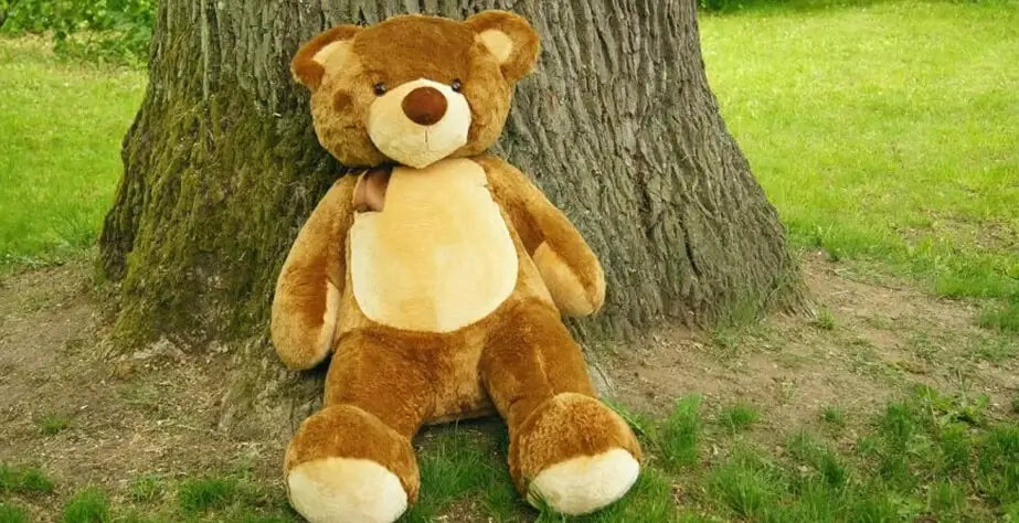 10 Creative Ways to Recycle and Reuse Your Old Stuffed Toys- Bear stuffed toy leaning on tree