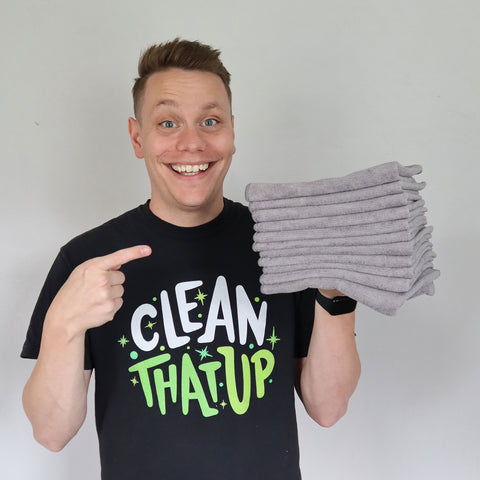 man holding stack of gray microfiber towels