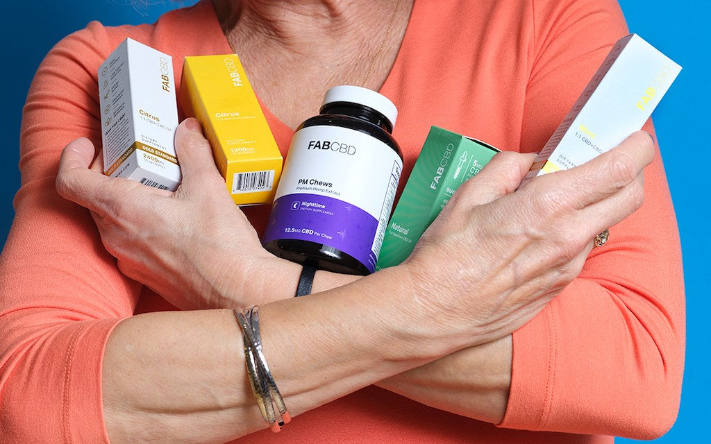 A woman holds an armful of CBD products