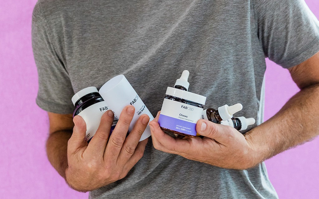 A man juggling a bunch of CBD products in his arms