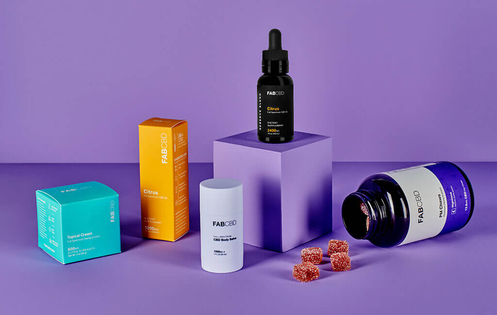 An array of CBD products placed on a purple backdrop