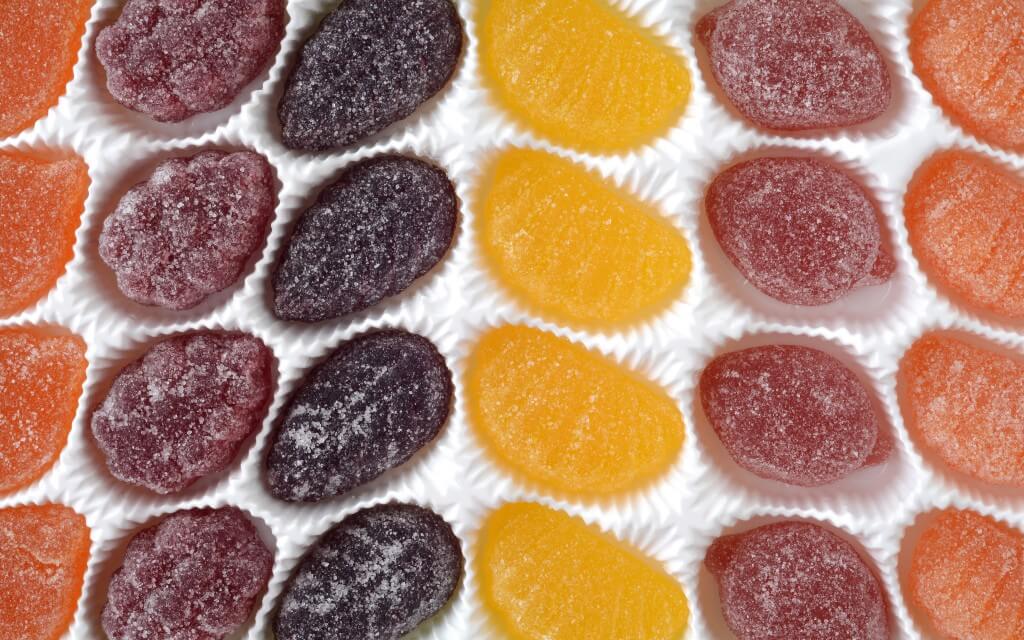 A molded tray holds gummies of different colors and shapes