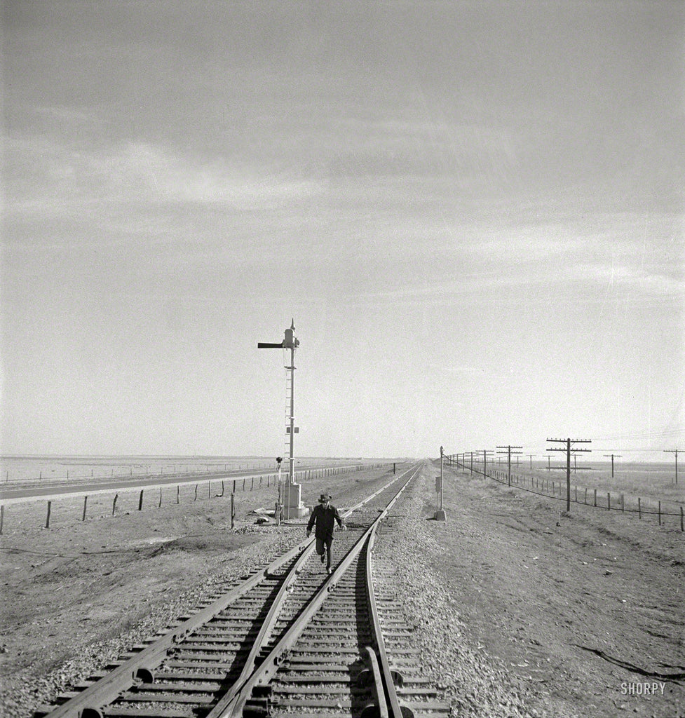 March 1943. "Summerfield, Texas. Brakeman running back to his train on the Atchison, Topeka & Santa Fe Railroad."