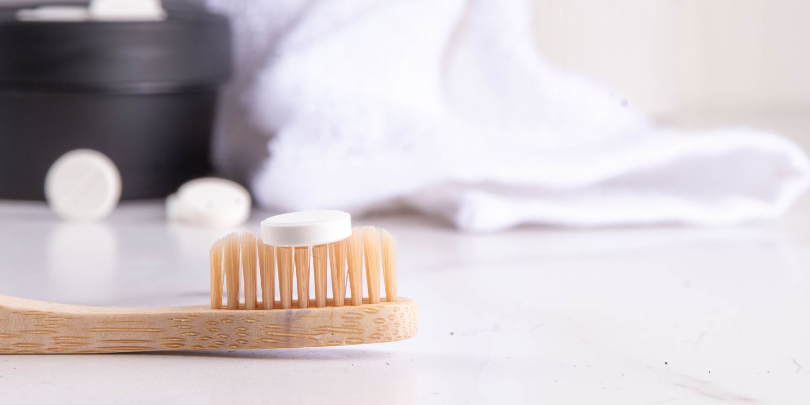 toothpaste tablet on bamboo toothbrush