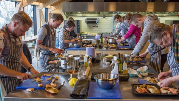 A group of people learning to cook during a cooking course