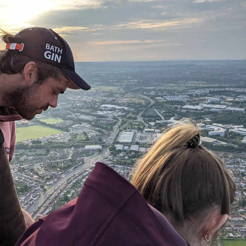 two people peering down on Bristol city centre from a hot air balloon