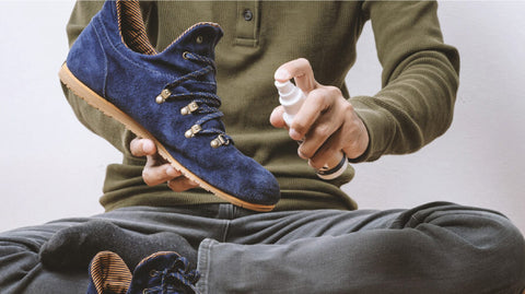 man cleaning one boot with spray bottle