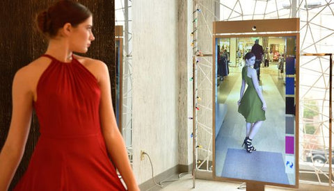 a woman looking at dresses option with interactive mirror