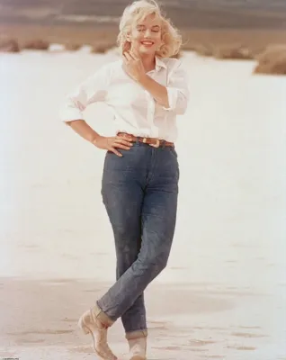 a woman wearing jeans with a white top