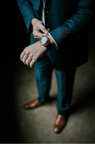 a man wearing a navy suit and a watch