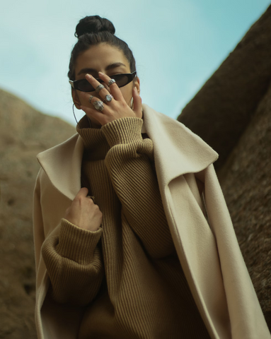 a woman a knitted sweatshirt and sunglasses