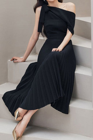 a woman wearing pleated black dress