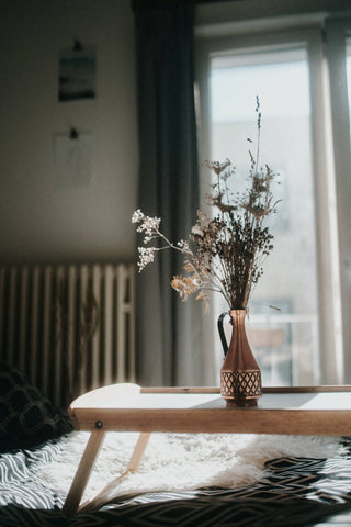 home picture with vase, table, window, curtains, cushion