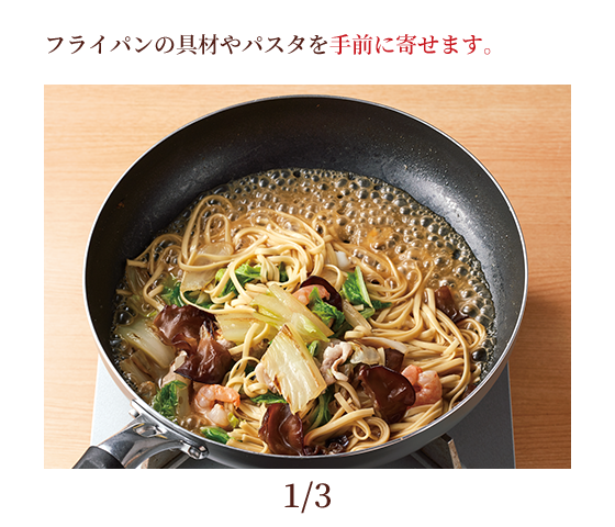 フライパンの具材やパスタを手前に寄せます。