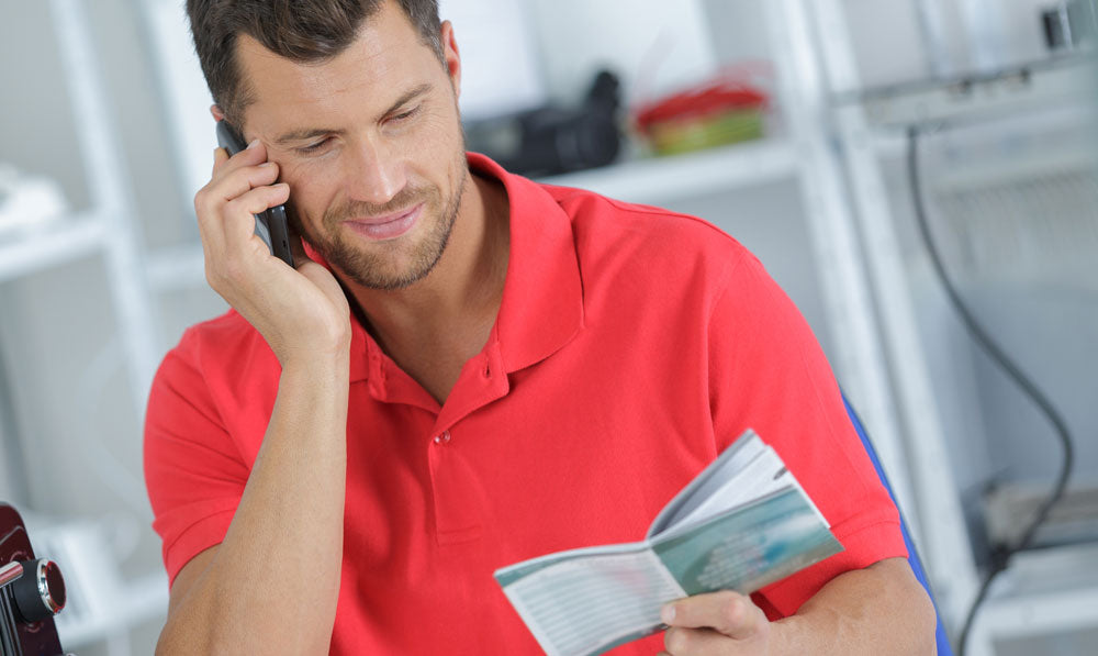 Man reading user manual while on the phone