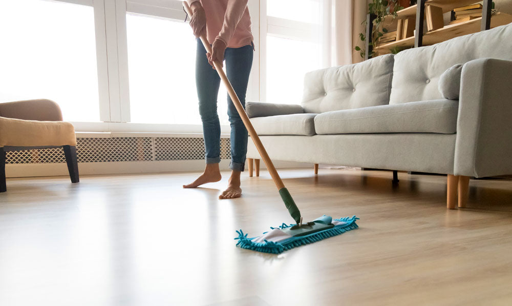 Woman cleaning the floor of her house with mop