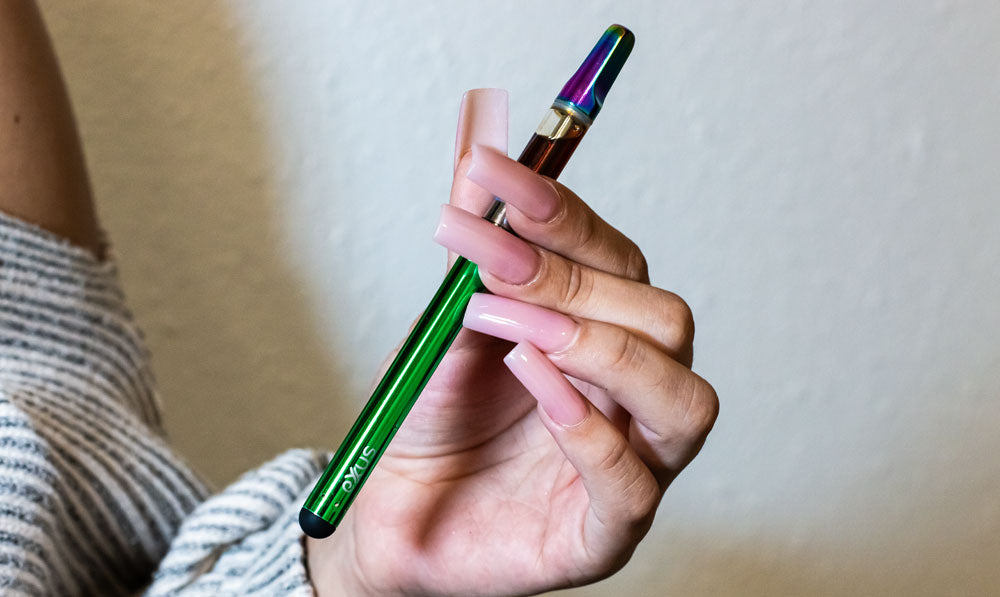 Woman holding Exxus Slim 2 in front of blank wall