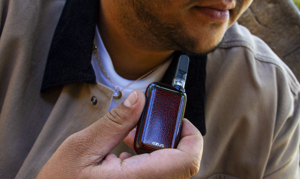 Man holding Exxus Rizo Crackle in front of tree bark under natural lighting