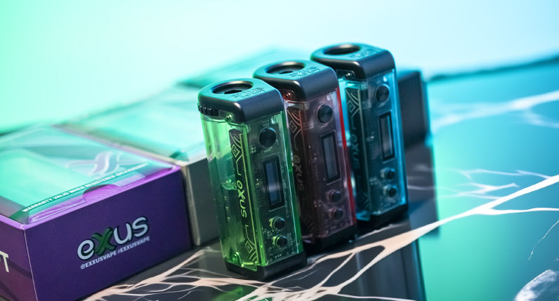 Exxus Adapt units standing on marble display in front of teal studio background with packaging nearby