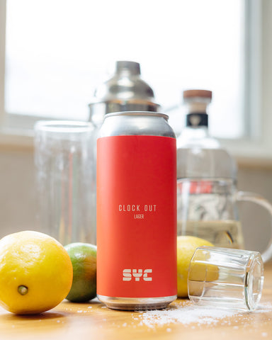 Clock Out Lager surrounded by ingredients for El Chonie cocktail