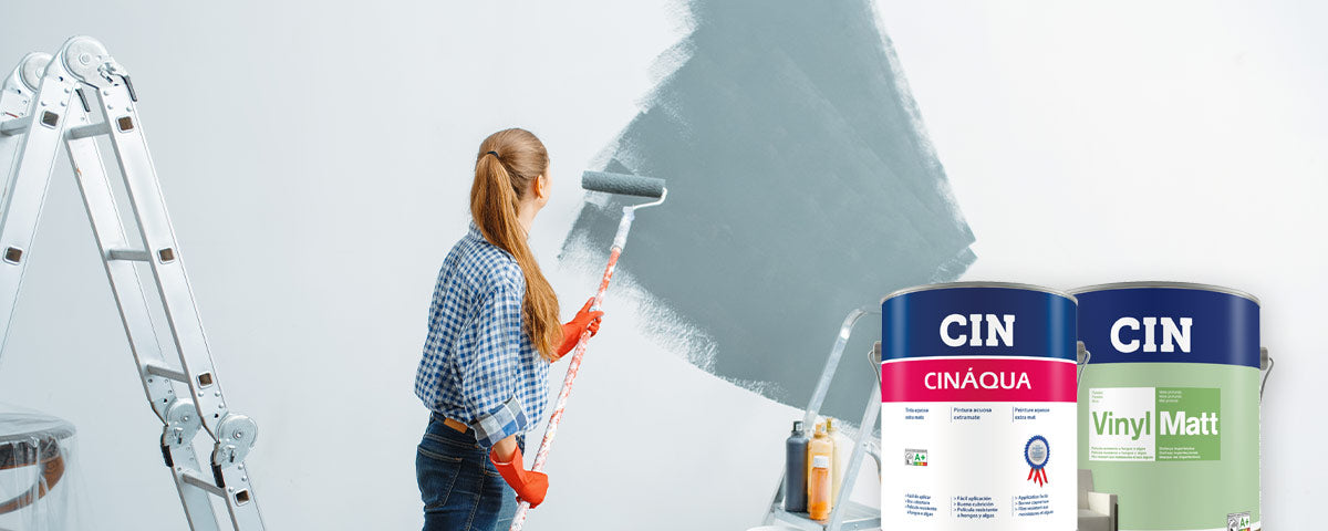 mulher a pintar uma parede de cinzento e exemplo de tintas para pintar paredes interiores