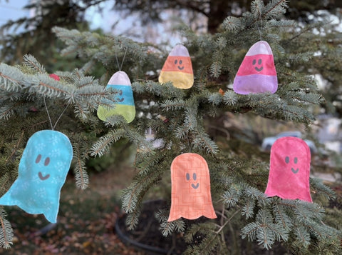 candy corn and ghost fabric ornaments in a tree