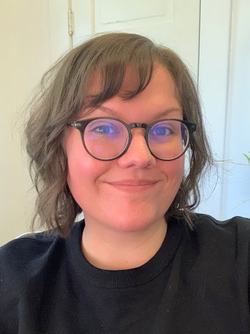 image of a thirtysomething white woman with brown hair, wearing a black shirt, smiling