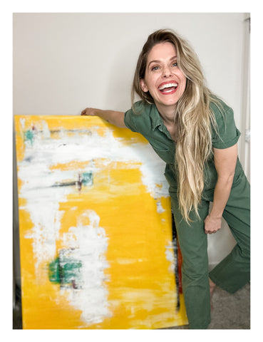Ash Christine Art smiling in front of an original abstract painting