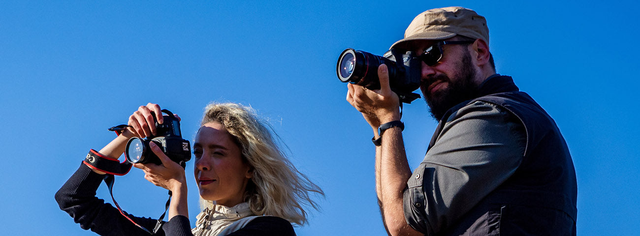 A man attaching a camera to SCOTTeVEST Q.U.E.S.T photographer vest