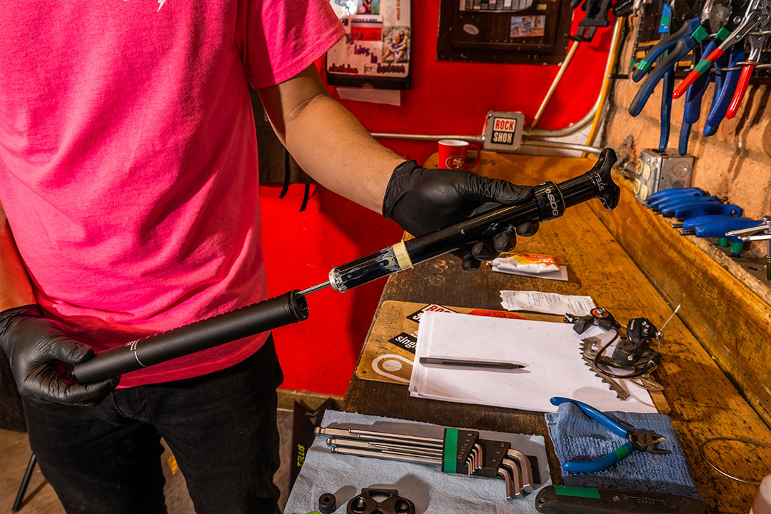 bike mechanic performing routine maintenance for dropper seatpost