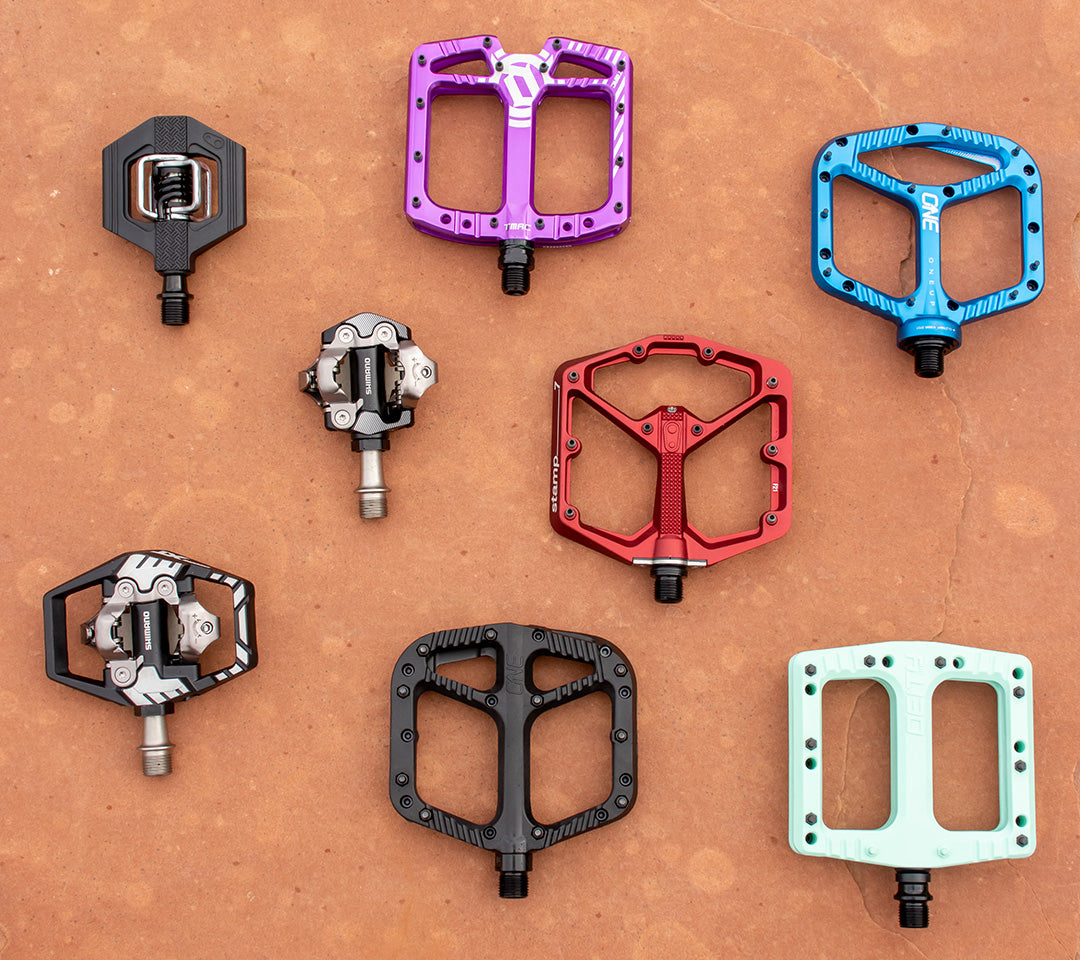 Clipless and flat mountain bike pedal assortment on red rocks