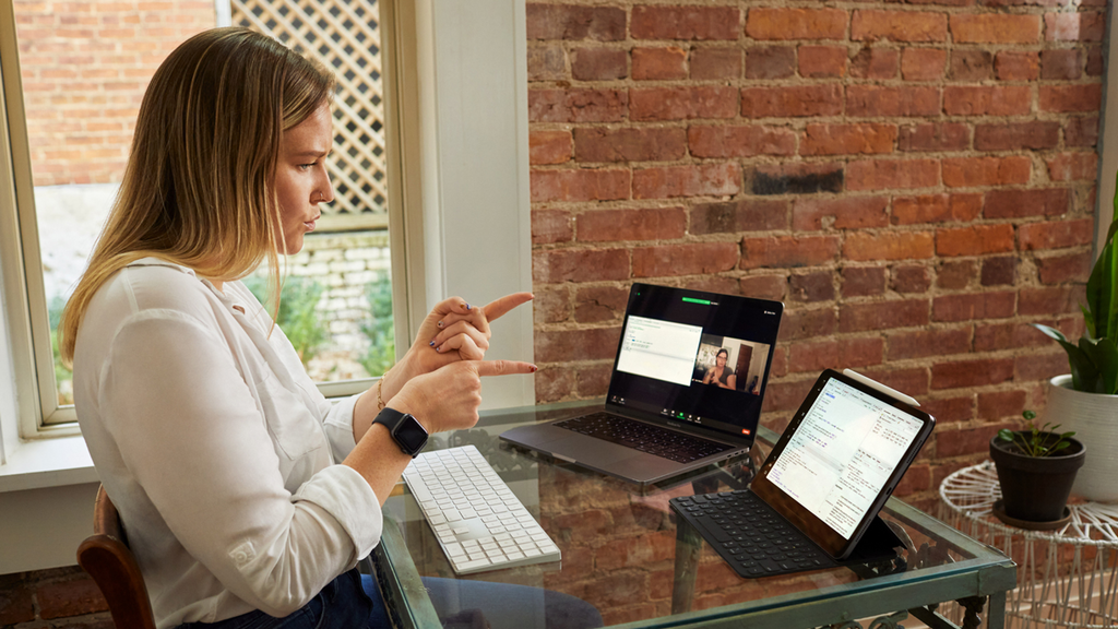 Una mujer trabajando en su escritorio modular con un Smart keyboard folio