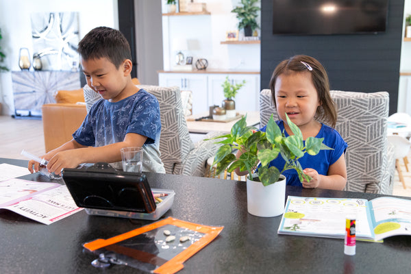 brother and sister at the kitchen counter with their STEAMbright kits